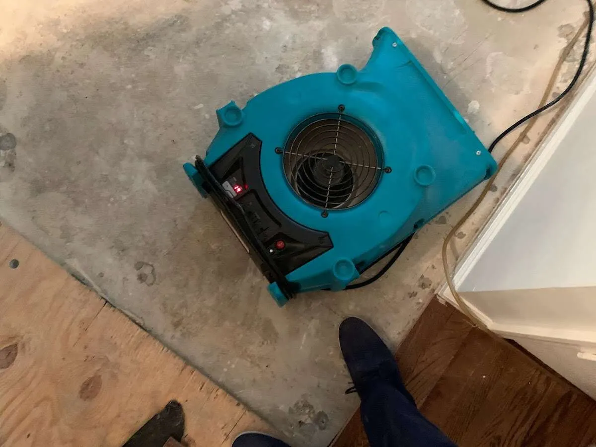 Air mover drying subfloor during Commercial Water Damage Restoration in Winters